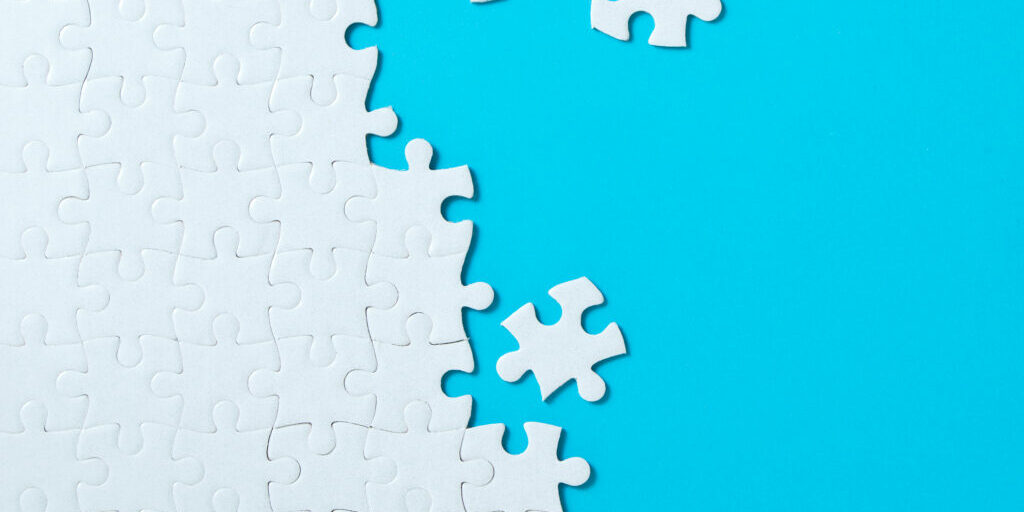 Unfinished,White,Jigsaw,Puzzle,Pieces,On,Blue,Background